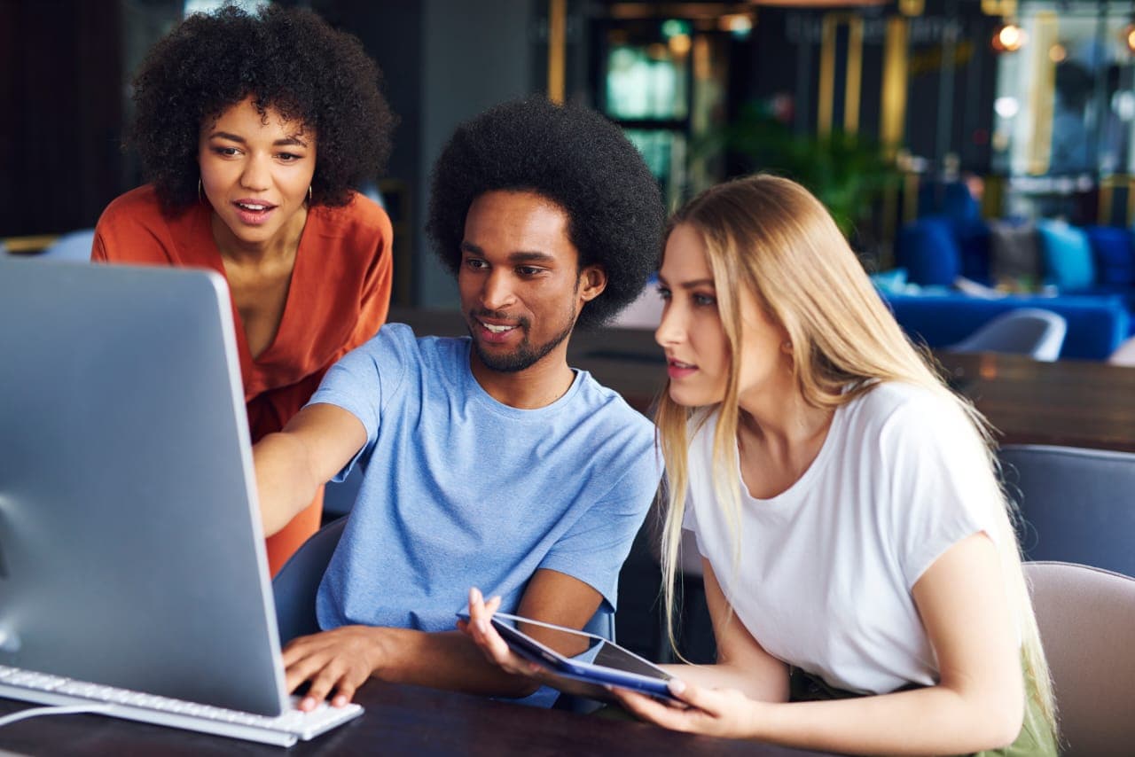 Three people reviewing a laptop together