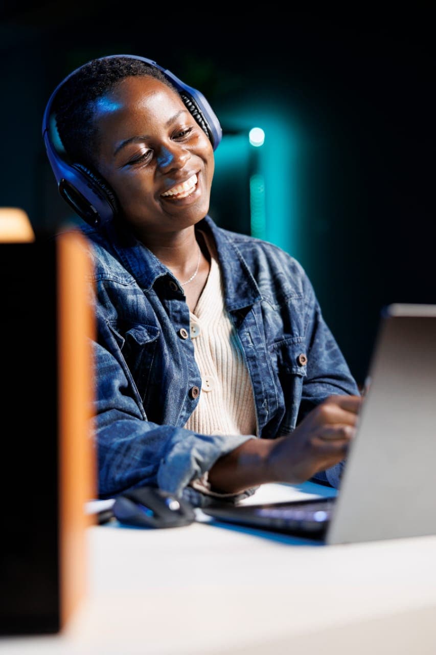 Student smiling while using a laptop